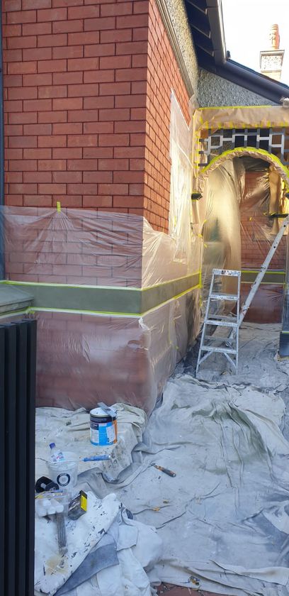 Work in progress photo showing covered house facade